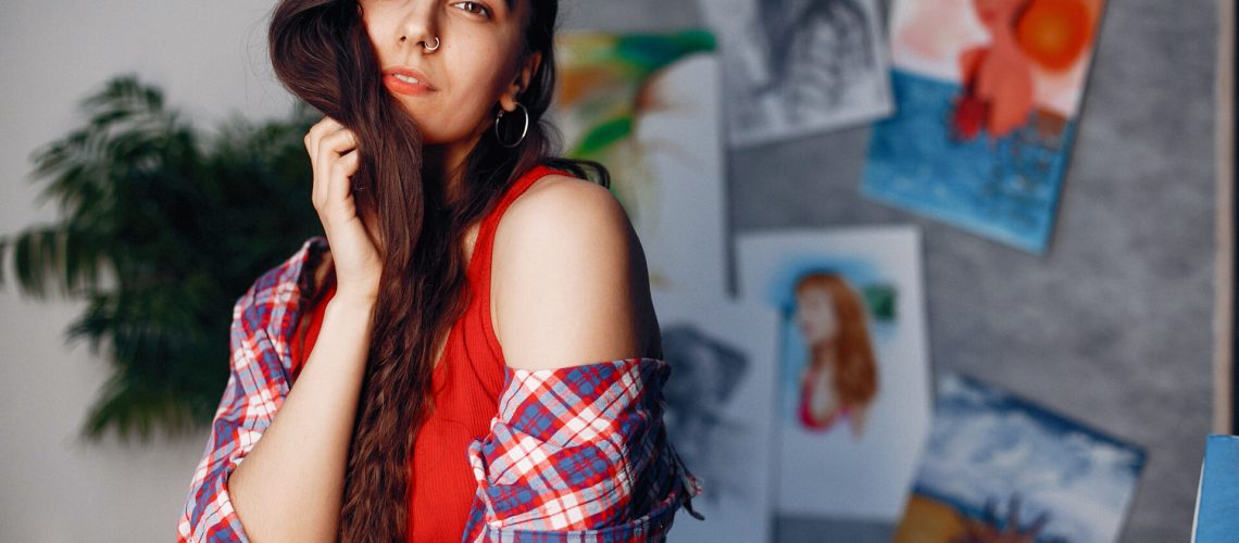 Beautiful girl in a room. Stylish girl in a red shirt